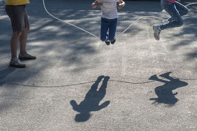 Low section of men playing with umbrella