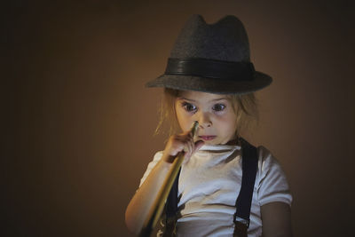 Charming child in retro clothes playing toy billiards.