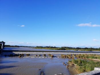Scenic view of beach against blue sky