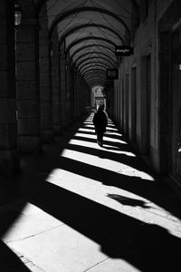 Rear view of person walking under archways