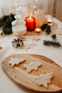 Christmas decorations and cookies metal form on table with burning candles