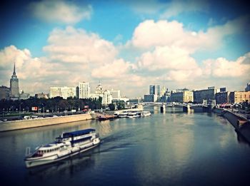 Boats in river with city in background