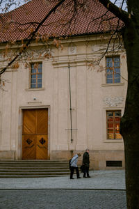 Rear view of people walking outside building