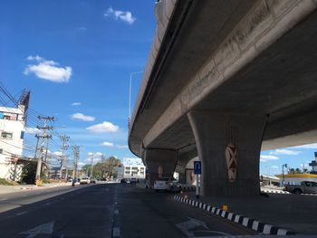 Road by bridge against sky in city