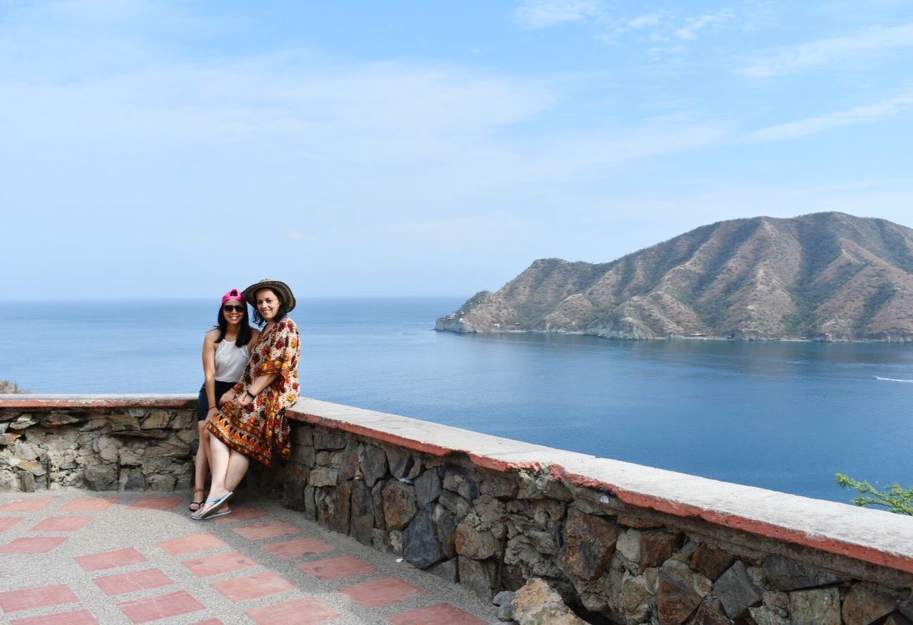 water, young adult, scenics - nature, mountain, sky, one person, beauty in nature, young women, full length, sea, nature, adult, tranquil scene, leisure activity, lifestyles, day, tranquility, cloud - sky, outdoors, mountain range, beautiful woman, hairstyle