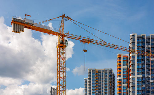 Low angle view of crane against sky