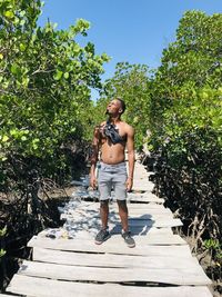 Full length of senior woman standing against plants