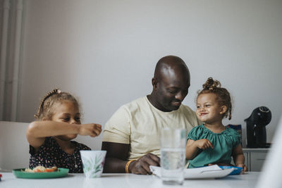 Father and daughters eating meal