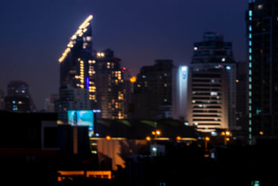 Illuminated buildings in city against sky at night