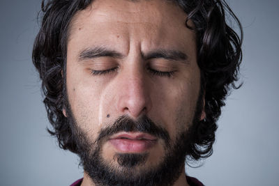 Close-up portrait of man against gray background