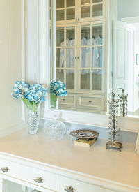 Flower vase on table by window at home