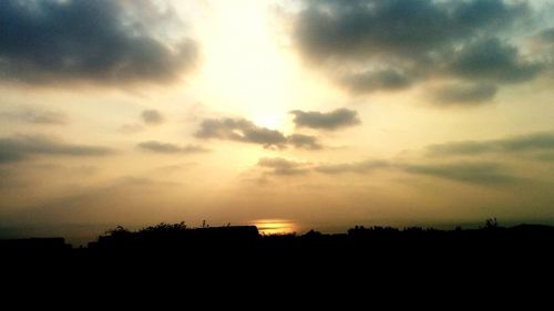 Silhouette of landscape against cloudy sky