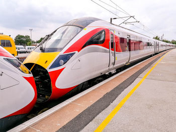 Train at railroad station platform against sky