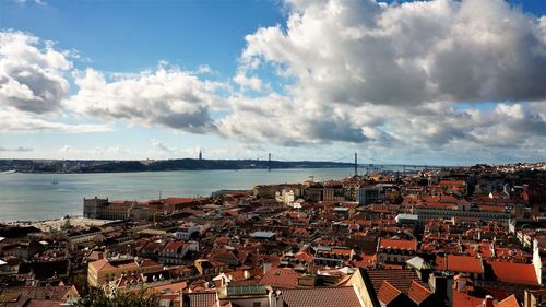 High angle view of cityscape by sea against sky