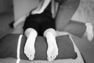 Low section of woman sitting on floor at home