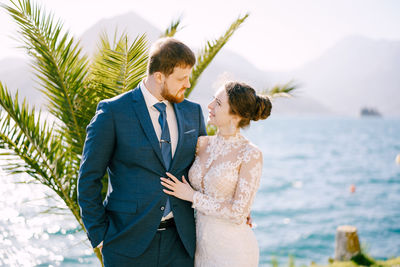 Young couple standing against sea