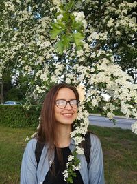 Portrait of smiling young woman against plants