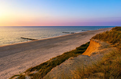 Scenic view of beach against sky during sunset