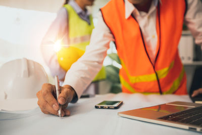 Midsection of man working on table