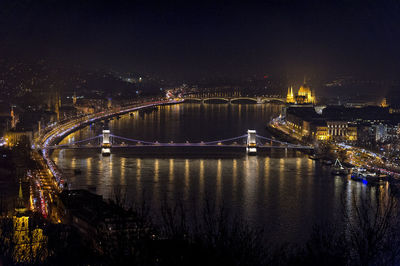 Illuminated bridge over river in city at night in budapest