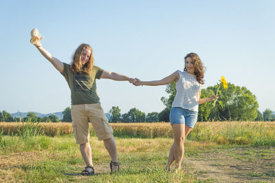 Full length of woman standing on field against clear sky