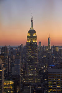 Illuminated empire state building in new york at sunset