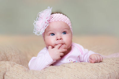 Cute baby girl lying down on bed