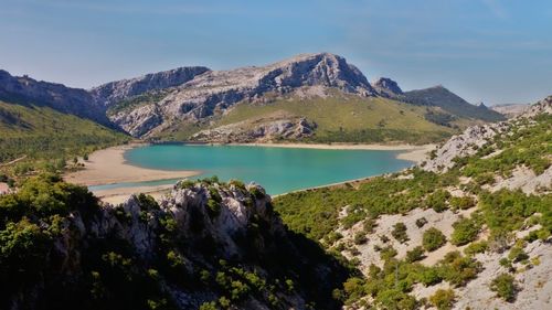 Scenic view of river and mountains against clear sky