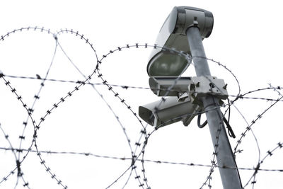 Low angle view of barbed wire against clear sky