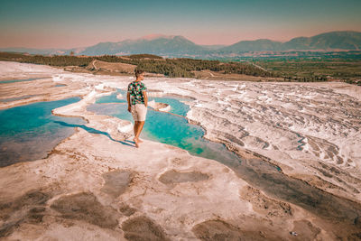 Full length of man walking on salt flat against sky