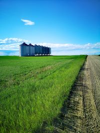 Grain silos on agricultural land with blue sky background.