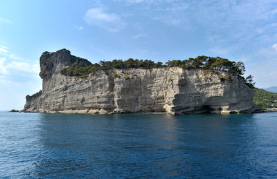 Rock formations in sea against sky