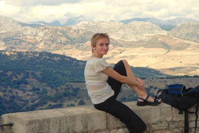 Portrait of smiling young woman against mountains