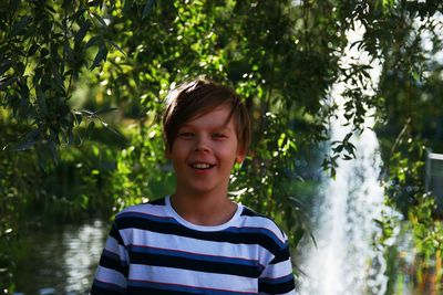 Portrait of smiling boy against trees