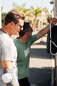 Two skateboarder friends chatting near their camper van in gran ganaria