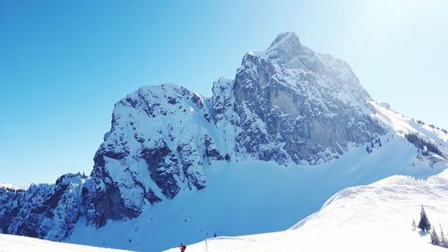 Scenic view of snowcapped mountains against clear blue sky