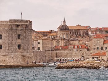 Town by sea against sky in city