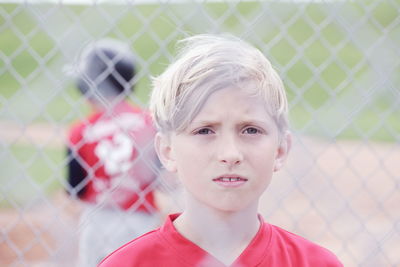 Portrait of boy against fence