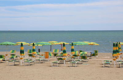 Chairs on beach against sky