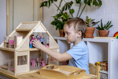 Boy playing with wooden toy at home