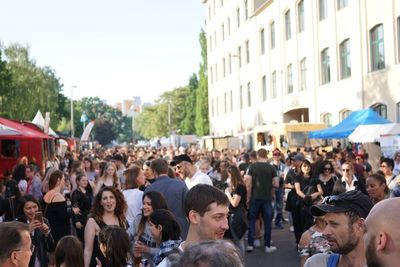 People on street in city against sky