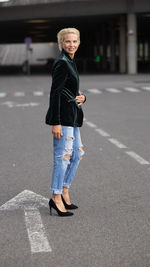 Portrait of young woman walking on road