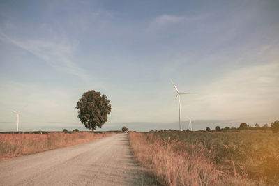 Road amidst field against sky