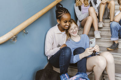 Friends sitting on sofa at home