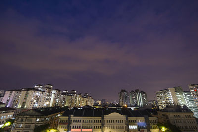 Illuminated buildings against sky at night