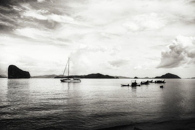Sailboats sailing in sea against sky