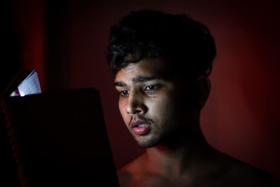 Close-up of shirtless man reading book