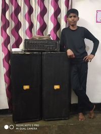 Portrait of young man standing against wall