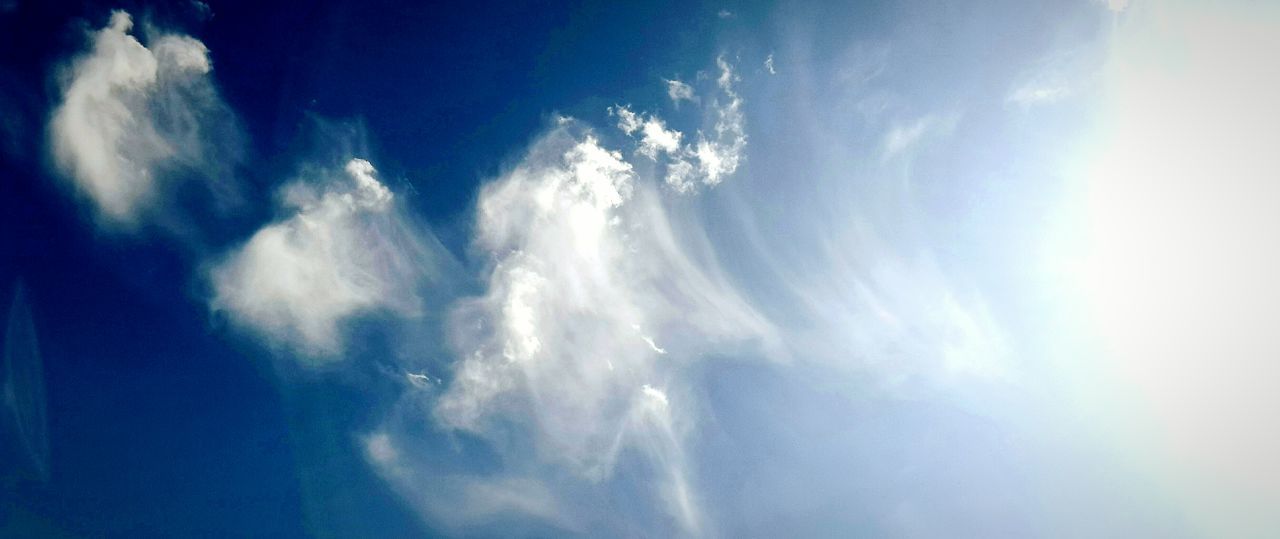 sky, low angle view, cloud - sky, blue, beauty in nature, sky only, cloud, tranquility, cloudy, nature, scenics, cloudscape, tranquil scene, sunlight, idyllic, sunbeam, outdoors, day, no people, backgrounds