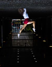 Upside down image of woman doing handstand on footpath in city